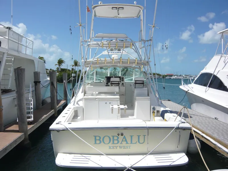 Slide: The Image of 2004 Rampage 38 Express boat docked in sunny marina, clear skies, and calm waters. - 4