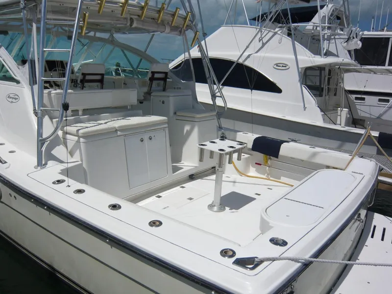 Slide: The Image of 2004 Rampage 38 Express boat with spacious deck and fishing setup at marina. - 5