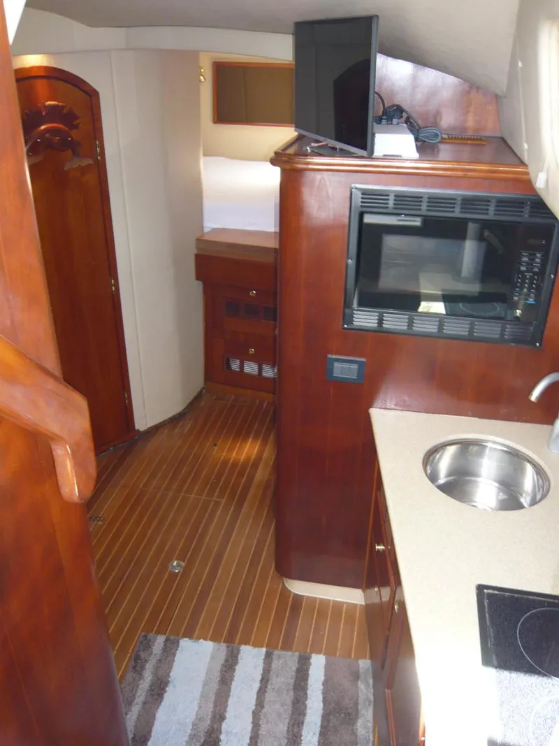 Slide: The Image of 2004 Rampage 38 Express interior with kitchenette, microwave, sink, and wood flooring. - 8