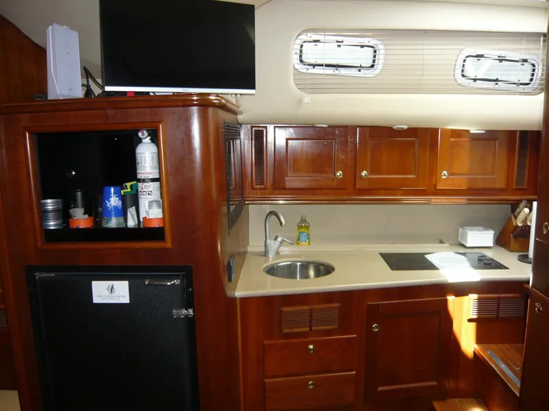 Slide: The Image of 2004 Rampage 38 Express yacht interior with wooden cabinets, kitchenette, and appliances. - 9