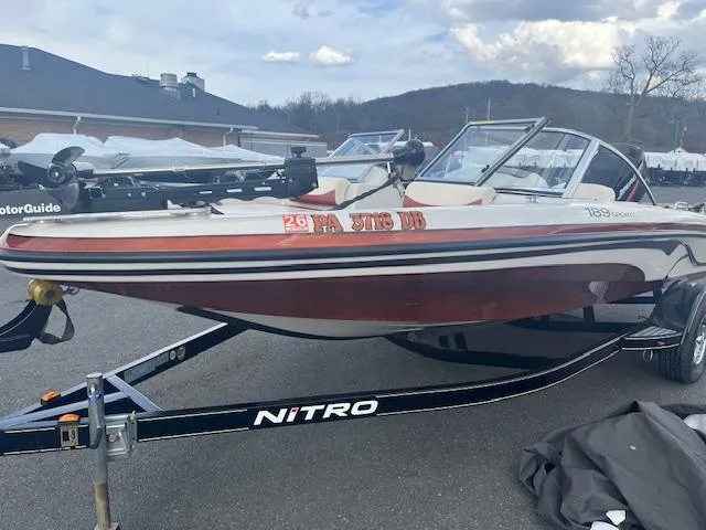 Slide: The Image of 2009 Nitro 189 Sport boat on trailer, parked outdoors with scenic mountain backdrop. - 10