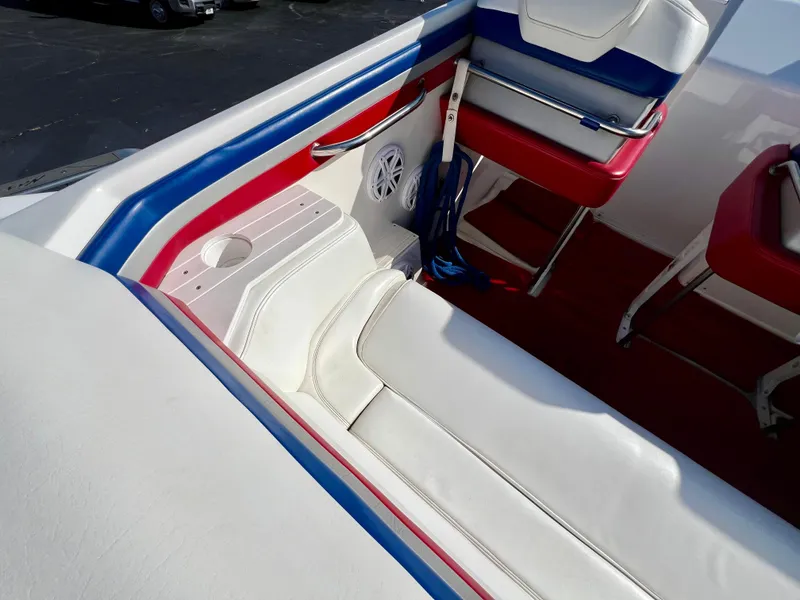 Slide: The Image of Interior of 1999 Black Thunder 430 Flat Deck boat with white, red, and blue seating. - 14
