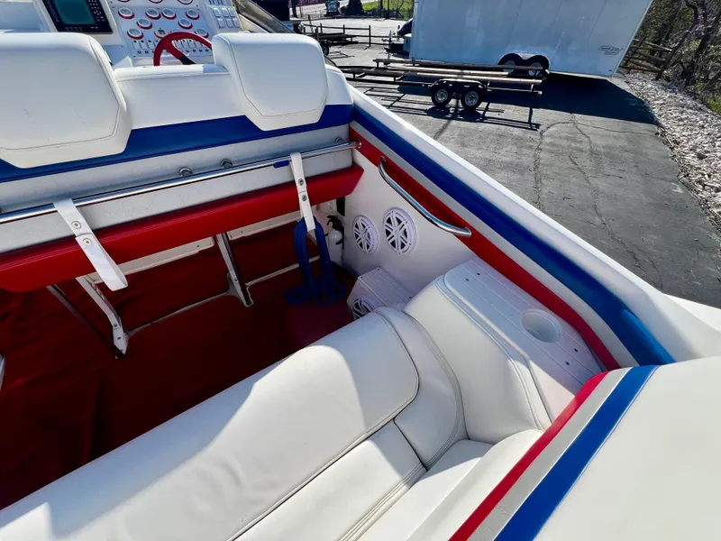 Slide: The Image of Interior of 1999 Black Thunder 430 Flat Deck boat with white, red, and blue seating. - 15