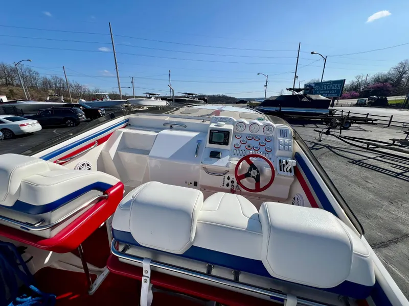 Slide: The Image of 1999 Black Thunder 430 Flat Deck boat with white and blue interior, docked under clear sky. - 16