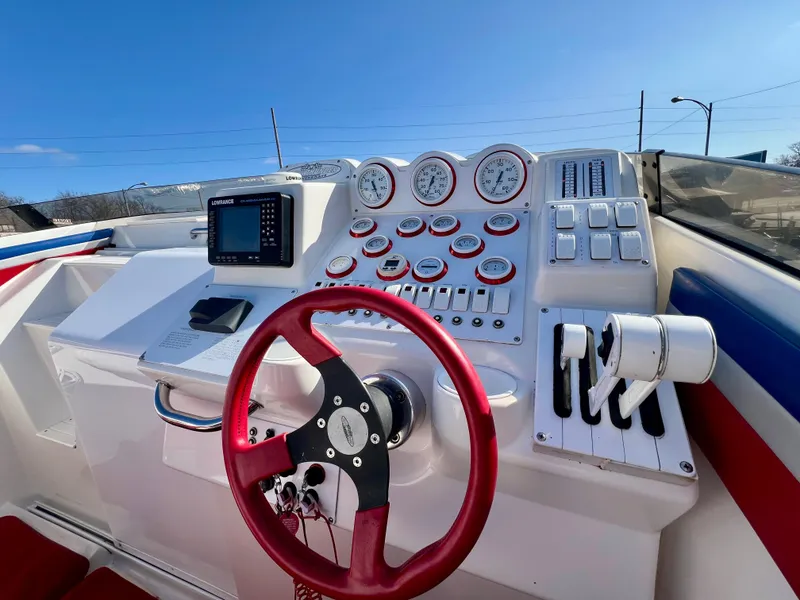 Slide: The Image of 1999 Black Thunder 430 Flat Deck boat dashboard with red steering wheel and gauges. - 19