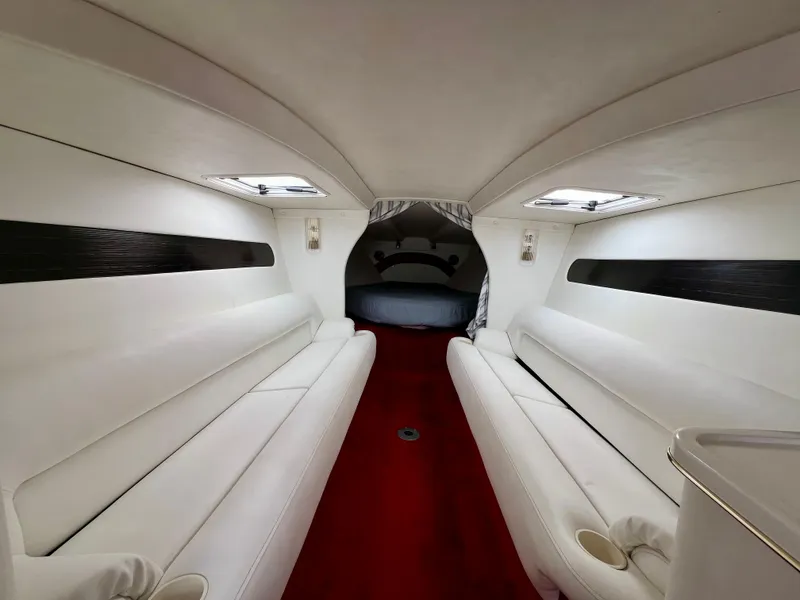 Slide: The Image of Interior of 1999 Black Thunder 430 Flat Deck boat with white seating and red carpet. - 24