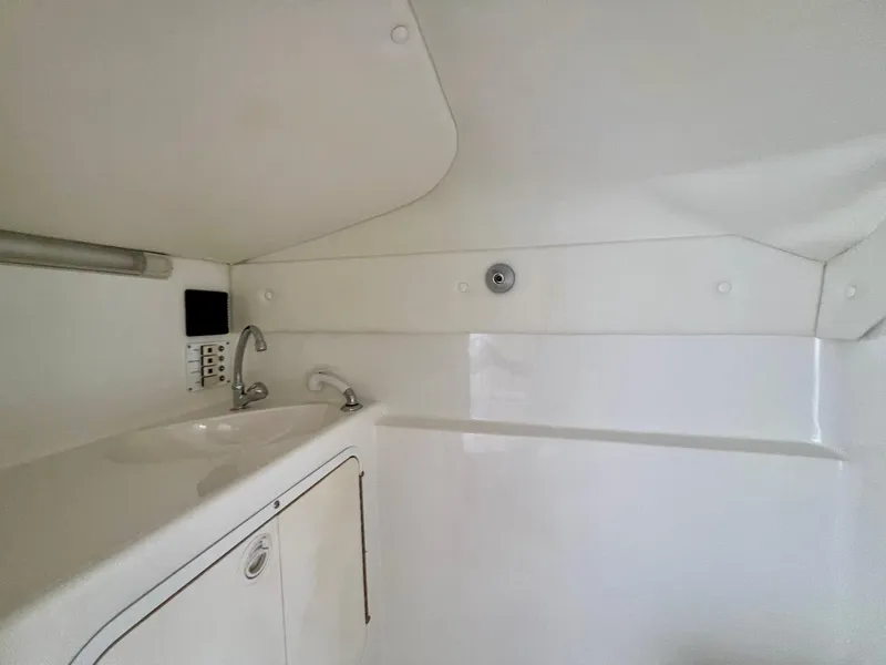 Slide: The Image of Interior of 1999 Black Thunder 430 Flat Deck boat, featuring a compact white sink area. - 29