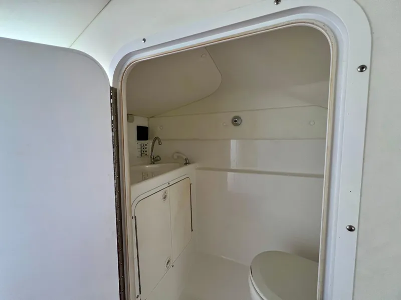 Slide: The Image of Interior of a 1999 Black Thunder 430 Flat Deck boat bathroom, featuring sink and toilet. - 30
