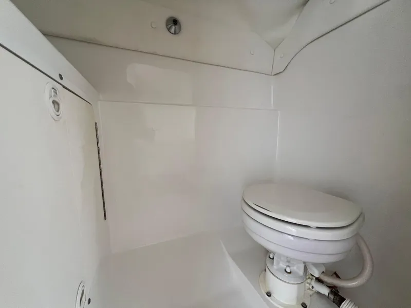 Slide: The Image of Interior of a 1999 Black Thunder 430 Flat Deck boat bathroom with white marine toilet. - 31