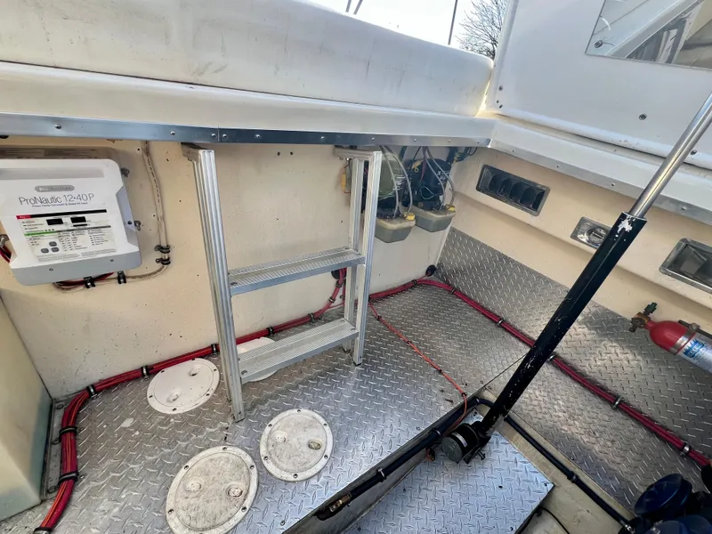 Slide: The Image of Interior of 1999 Black Thunder 430 Flat Deck boat with metal ladder and diamond plate flooring. - 33