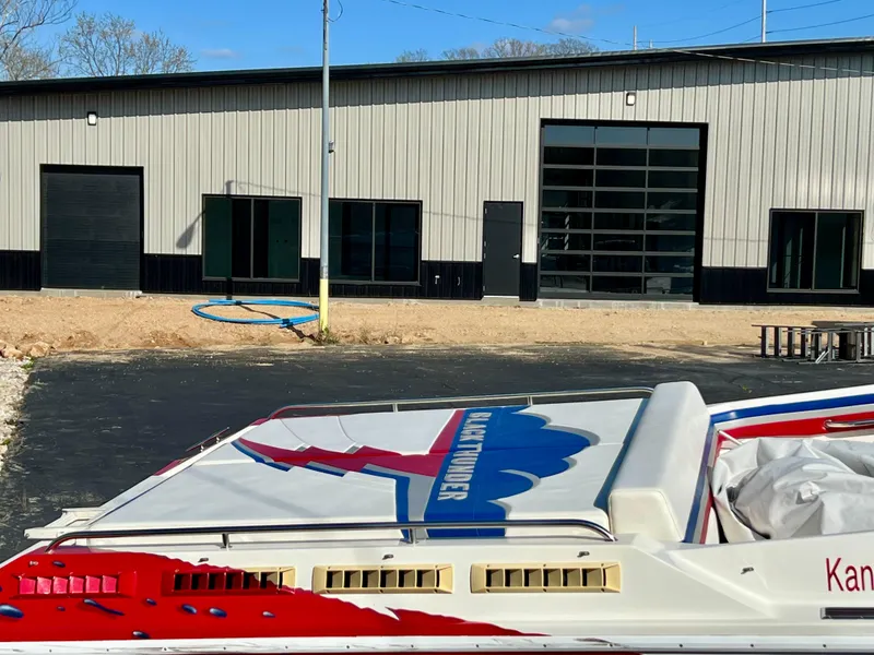 Slide: The Image of 1999 Black Thunder 430 Flat Deck boat near industrial building. - 7