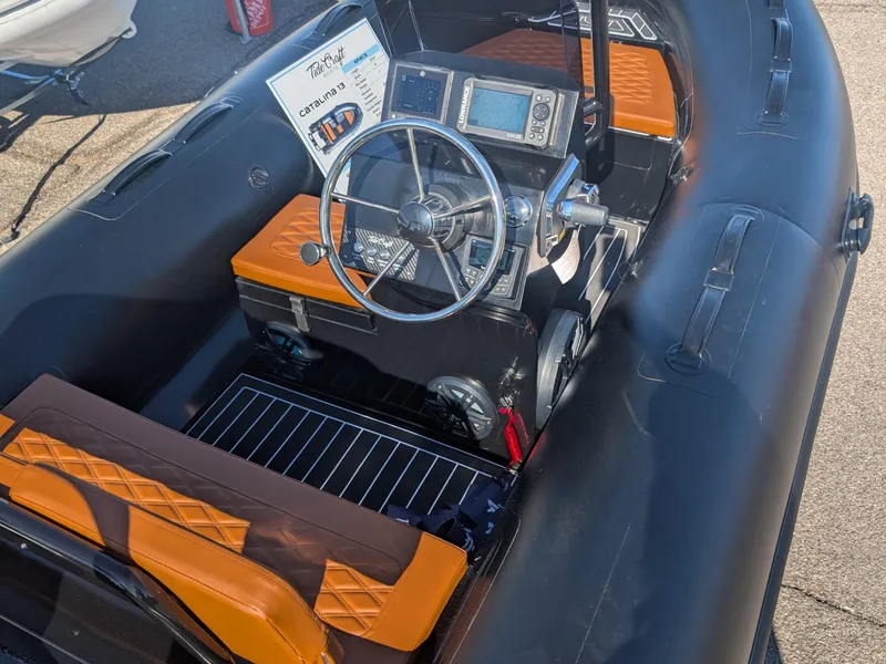 Slide: The Image of 2025 Tide Craft Custom Catalina 13 boat interior with orange seats and steering console. - 13