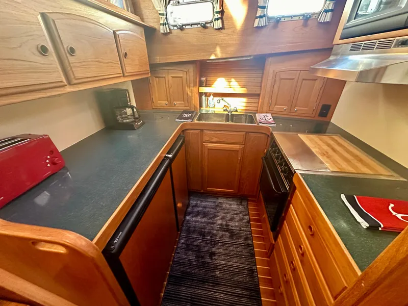 Slide: The Image of 1997 Sabre Cockpit Motor Yacht kitchen with wooden cabinets and modern appliances. - 18