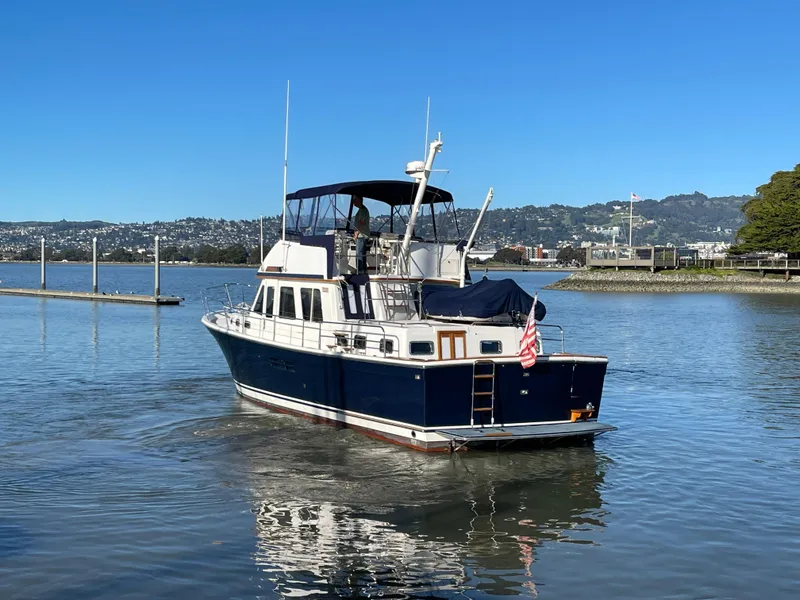 Slide: The Image of 1997 Sabre Cockpit Motor Yacht on calm water, clear sky, scenic background. - 5