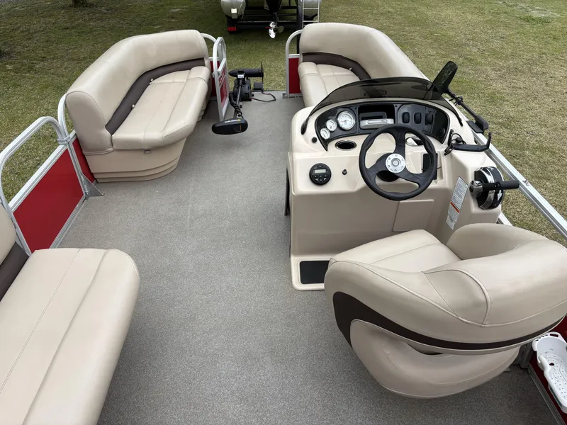 Slide: The Image of 2017 Sun Tracker Party Barge 18 DLX interior with beige seating and steering console. - 15