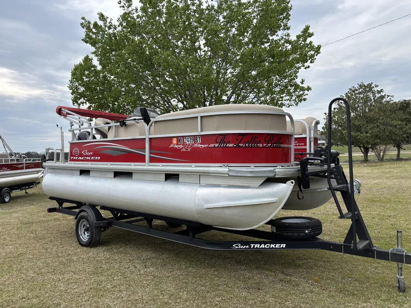 Slide: The Image of 2017 Sun Tracker Party Barge 18 DLX pontoon boat on trailer, parked on grass. - 3