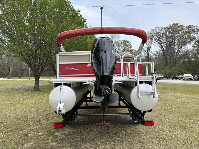 Slide: The Image of 2017 Sun Tracker Party Barge 18 DLX pontoon boat on grassy area, rear view. - 7