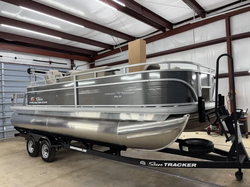 Slide: The Image of 2025 Sun Tracker Fishin Barge 20 DLX pontoon boat in a storage facility. - 11