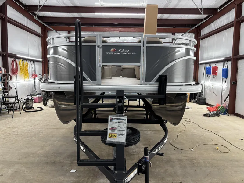 Slide: The Image of 2025 Sun Tracker Fishin Barge 20 DLX pontoon boat in a garage setting. - 14