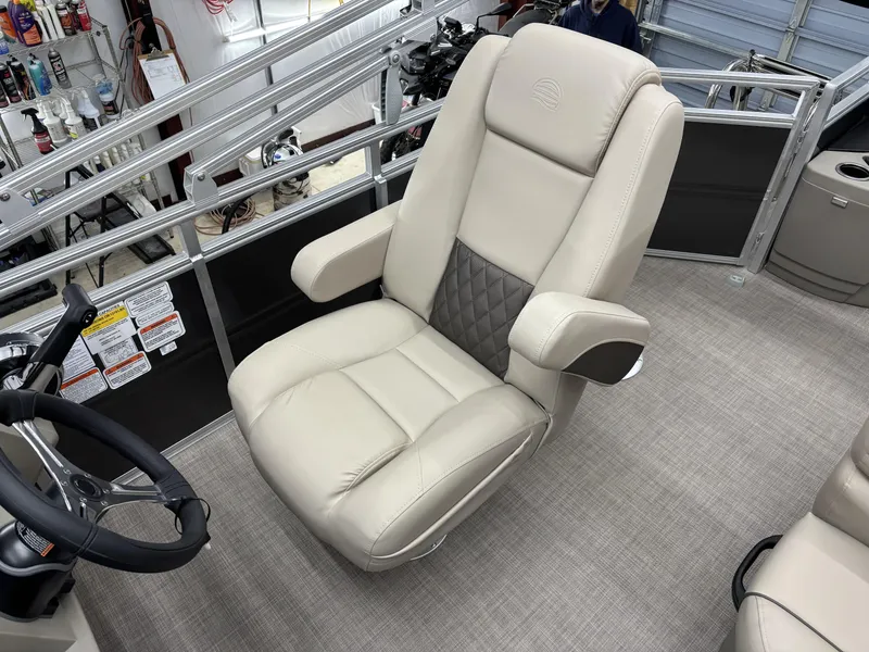 Slide: The Image of 2025 Sun Tracker Fishin Barge 20 DLX captain's chair, beige with quilted accents, in a boat interior. - 16