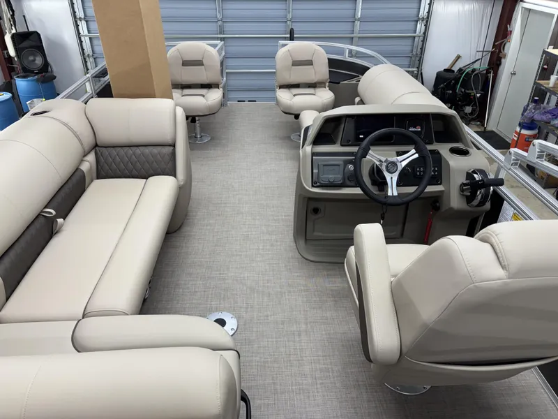 Slide: The Image of 2025 Sun Tracker Fishin Barge 20 DLX interior with beige seating and steering console. - 8