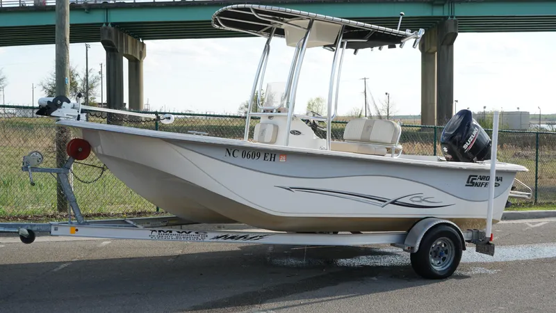 Slide: The Image of 2018 Carolina Skiff 198DLV boat on trailer, parked near a bridge. - 6