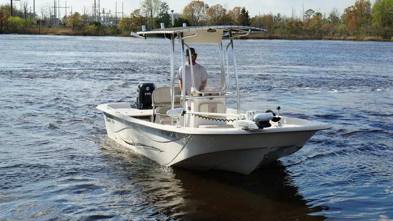 Slide: The Image of 2018 Carolina Skiff 198DLV boat navigating on a calm river. - 8