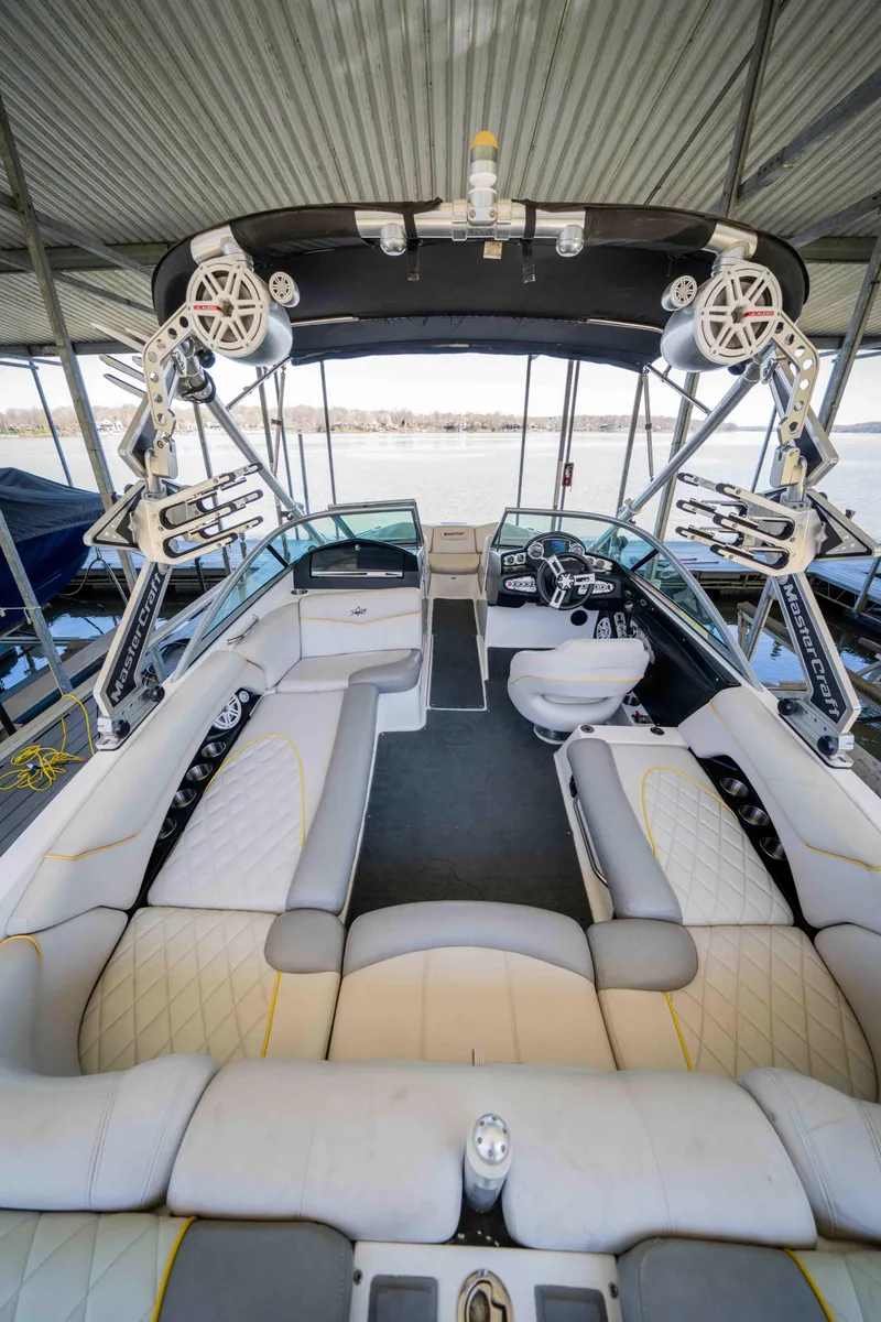 Slide: The Image of 2010 MasterCraft X25 boat interior with white seating and advanced audio system. - 10