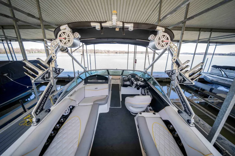 Slide: The Image of 2010 MasterCraft X25 boat interior with seating and wakeboard tower in a docked position. - 18
