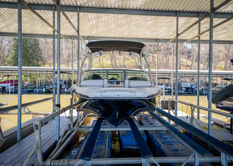 Slide: The Image of 2010 MasterCraft X25 boat docked in covered marina, front view. - 2
