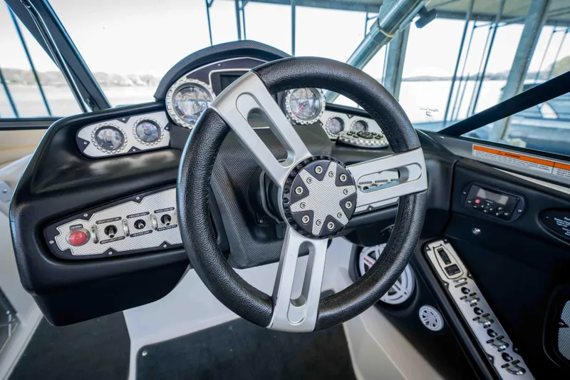 Slide: The Image of Steering wheel and dashboard of 2010 MasterCraft X25 boat, featuring gauges and controls. - 24