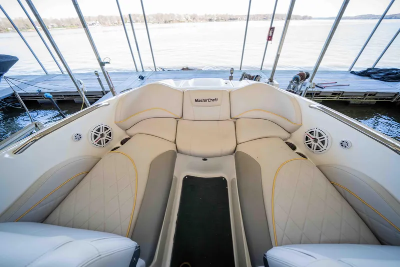 Slide: The Image of 2010 MasterCraft X25 boat interior with beige seating and lake view. - 27
