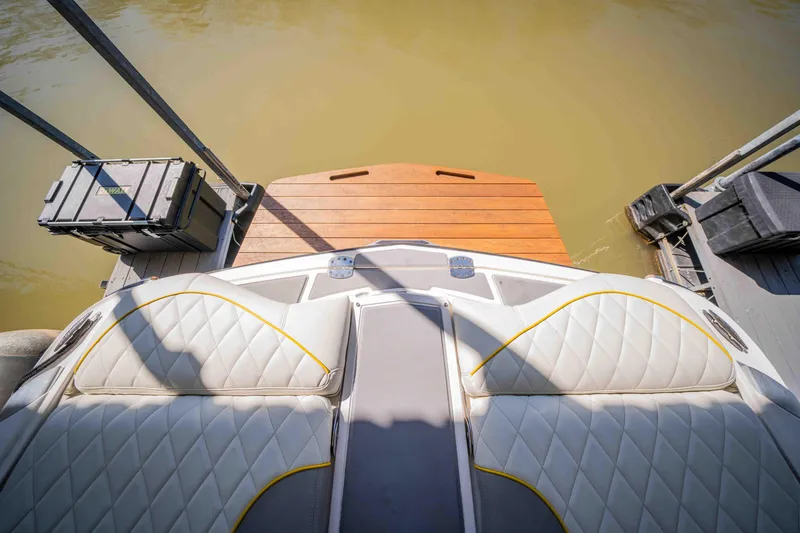 Slide: The Image of 2010 MasterCraft X25 boat interior with white quilted seats and wooden swim platform. - 32