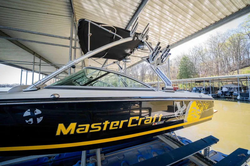 Slide: The Image of 2010 MasterCraft X25 boat docked under a covered marina. - 4