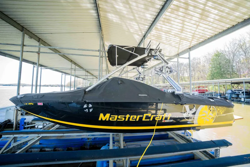 Slide: The Image of 2010 MasterCraft X25 boat docked under a covered marina. - 8