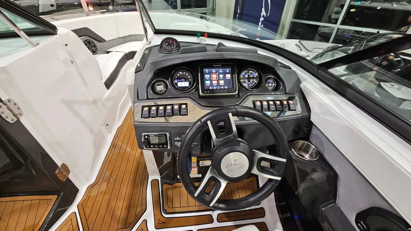 Slide: The Image of 2016 Monterey 258 Super Sport boat dashboard with modern controls and wood accents. - 13