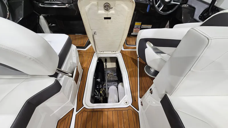 Slide: The Image of 2016 Monterey 258 Super Sport interior with open storage compartment and white seating. - 22
