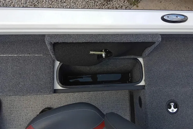 Slide: The Image of 2022 Ranger VS1665T boat storage compartment with open lid, gray interior, and seat visible. - 16
