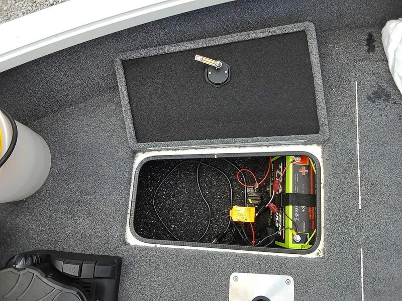 Slide: The Image of 2022 Ranger VS1665T boat battery compartment with wiring and storage hatch. - 8