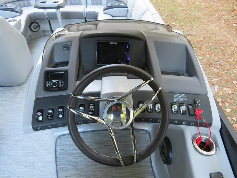 Slide: The Image of 2020 Bennington 25QXSBWAIO boat dashboard with steering wheel and control panel. - 10