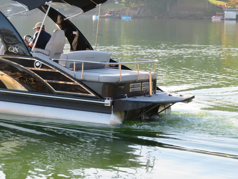Slide: The Image of 2020 Bennington 25QXSBWAIO pontoon boat cruising on a calm lake. - 9