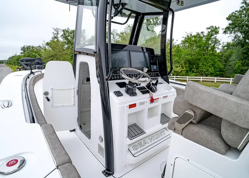 Slide: The Image of 2025 Sea Hunt Gamefish 30 CB boat cockpit with steering wheel and seating. - 24