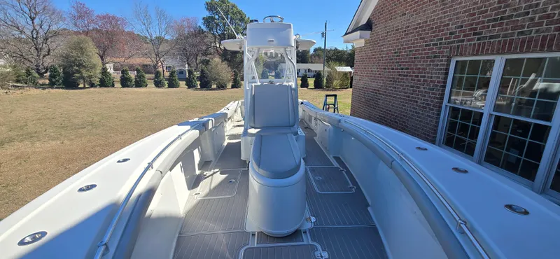 Slide: The Image of 2017 Yellowfin 36 boat docked beside a brick house, showcasing spacious deck and seating. - 11