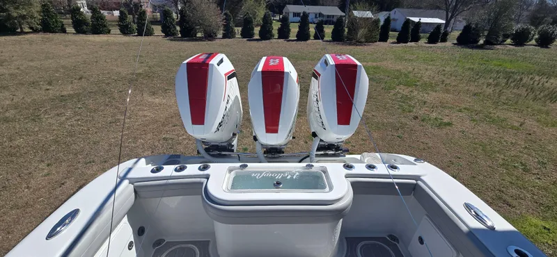 Slide: The Image of 2017 Yellowfin 36 boat with three powerful outboard engines, parked on grassy area. - 13