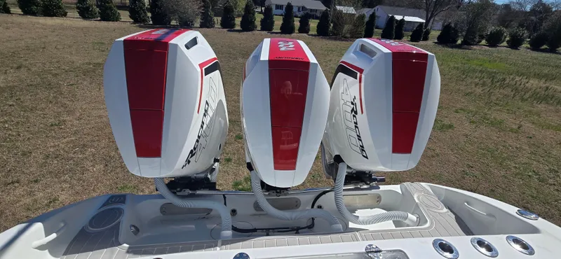 Slide: The Image of Triple outboard motors on a 2017 Yellowfin 36 boat, parked on grass. - 14