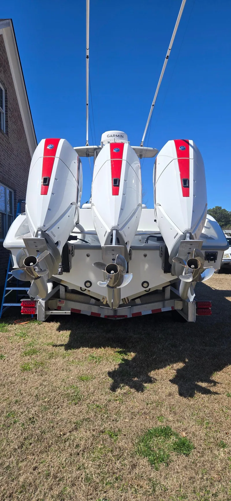 Slide: The Image of 2017 Yellowfin 36 boat with triple outboard engines, parked on grass. - 19