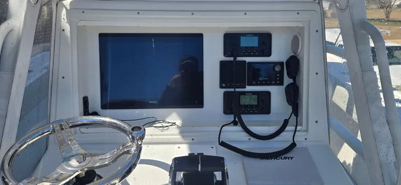 Slide: The Image of Control panel of a 2017 Yellowfin 36 boat with steering wheel and electronic displays. - 3