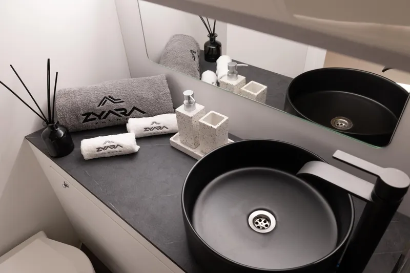 Slide: The Image of Modern bathroom with black sink, branded towels, and toiletries on a sleek countertop. - 12