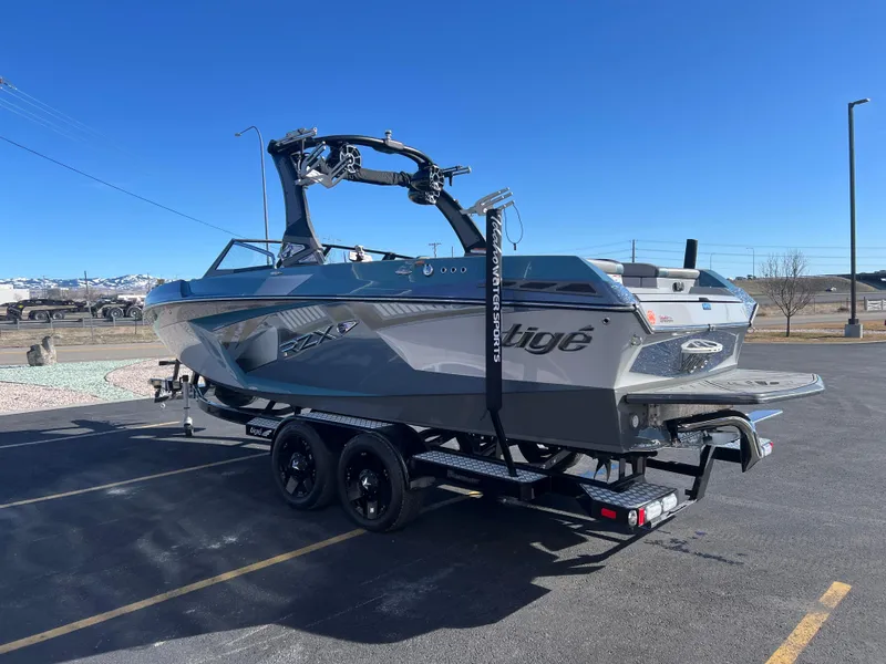 Slide: The Image of 2018 Tigé RZX3 boat on trailer under clear blue sky. - 10