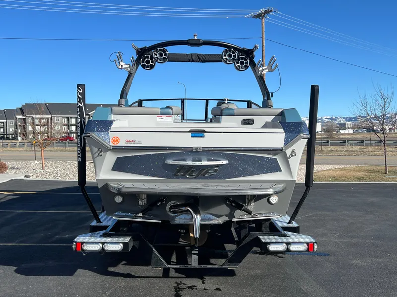 Slide: The Image of 2018 Tigé RZX3 boat rear view in parking lot under clear blue sky. - 11